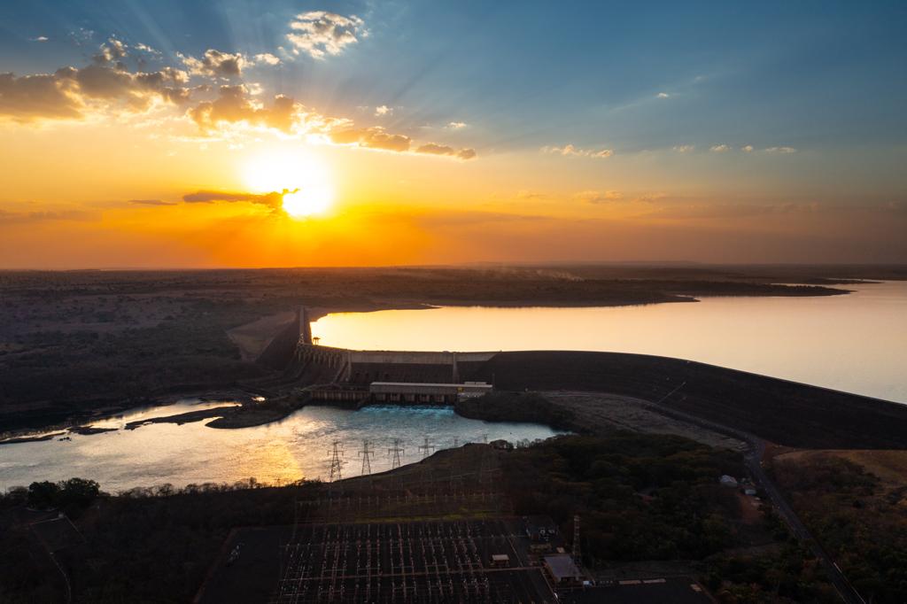 Imagem de barragem de hidrelétrica vista de cima, na hora do pôr-do-sol, simbolizando presença da SPIC no Brasil